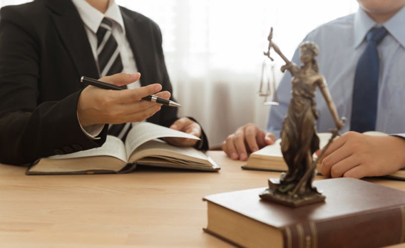 Law, Legal advice, Legislation concept. Lady justice on law book with lawyer and client in law office.